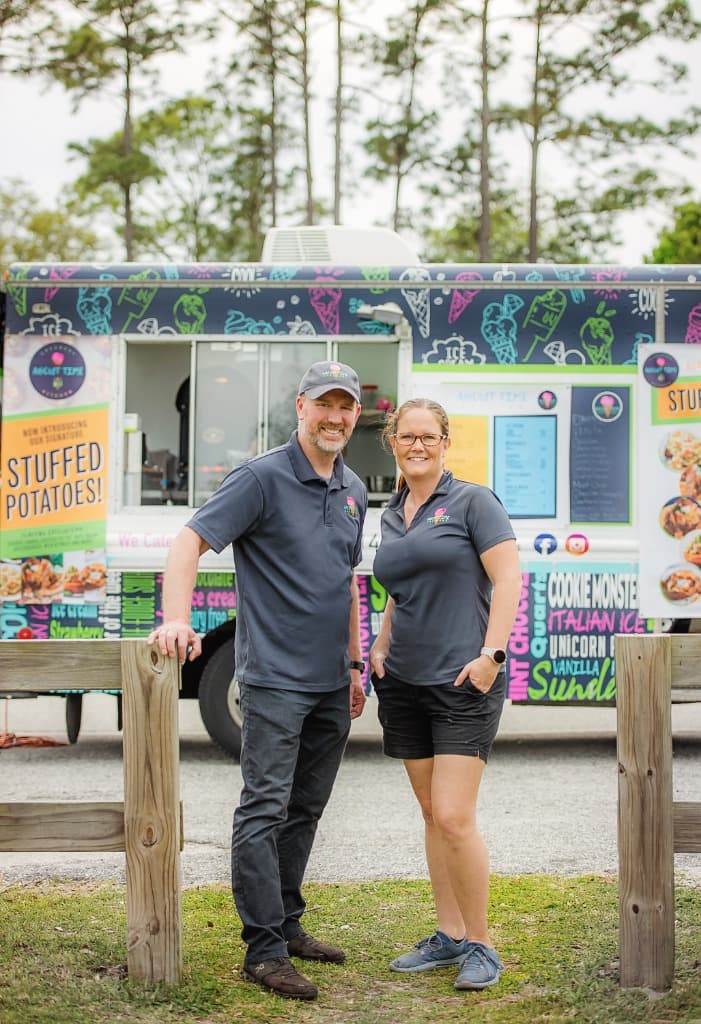 Cristie and Keith standing in front of their food truck