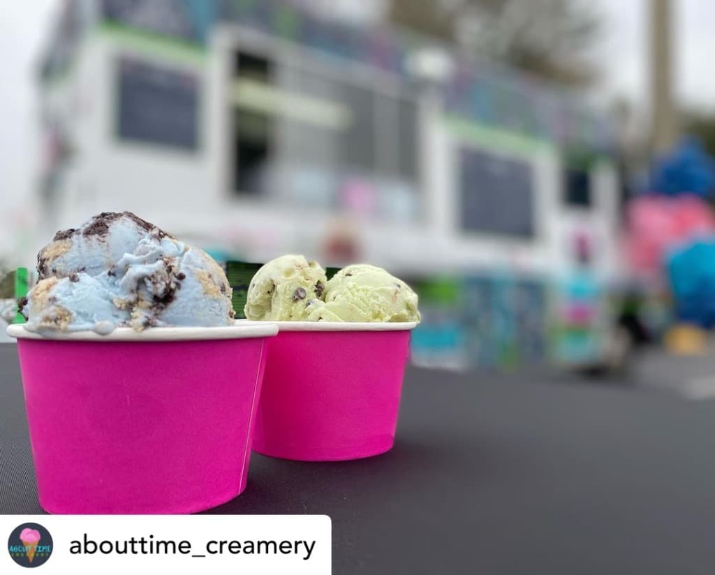 Two pink cups of ice cream in front of the About Time Creamery truck