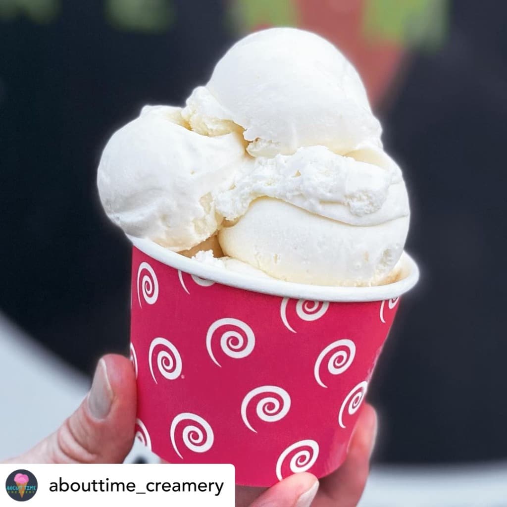 A pink swirl cup filled with scoops of vanilla ice cream